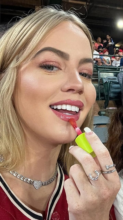 A reviewer applying the lip oil to their lips