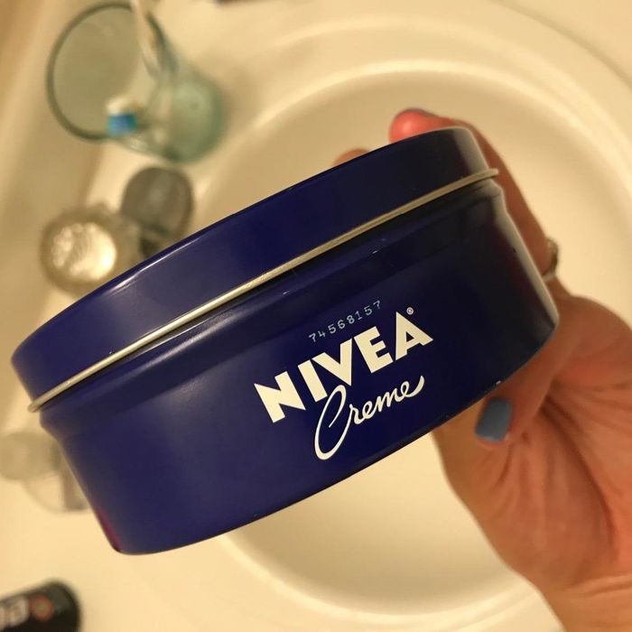 Reviewer holding a tub of Nivea Creme