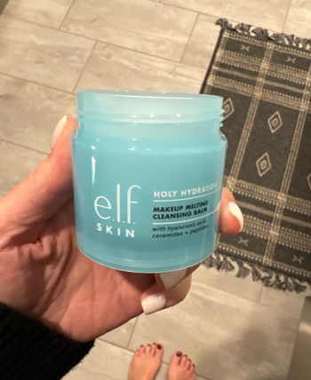 A person holding a jar of E.l.f. Holy Hydration! Makeup Melting Cleansing Balm