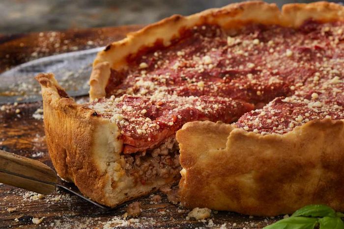 A deep dish pizza with a slice removed