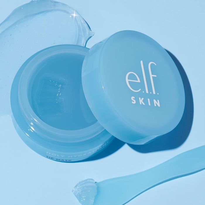 The e.l.f. Skin Holy Hydration! Lip Mask, with a small applicator and a dab of the product, resting beside it