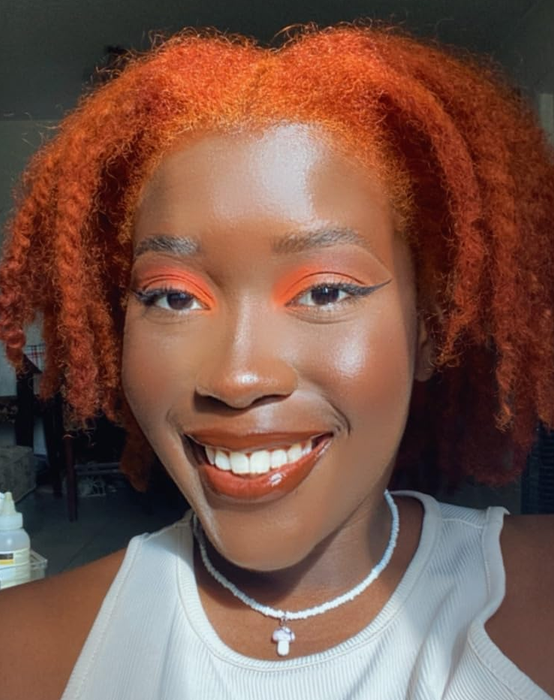 A different reviewer wearing the lip oil and showing off its glossy finish