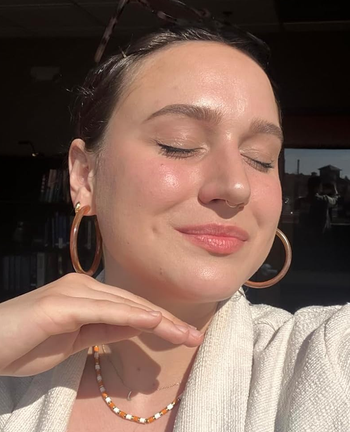 Reviewer showcasing their glowing makeup look using the Lumi Glotion for a dewy finish