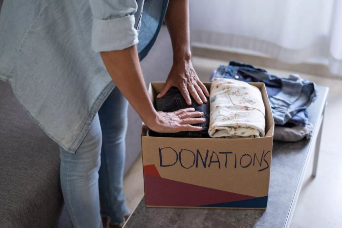 Woman placing clothes in a box to donate
