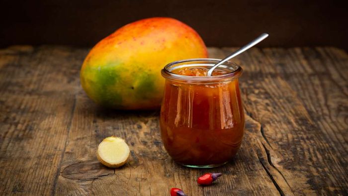 A glass of mango chutney with ginger and chili