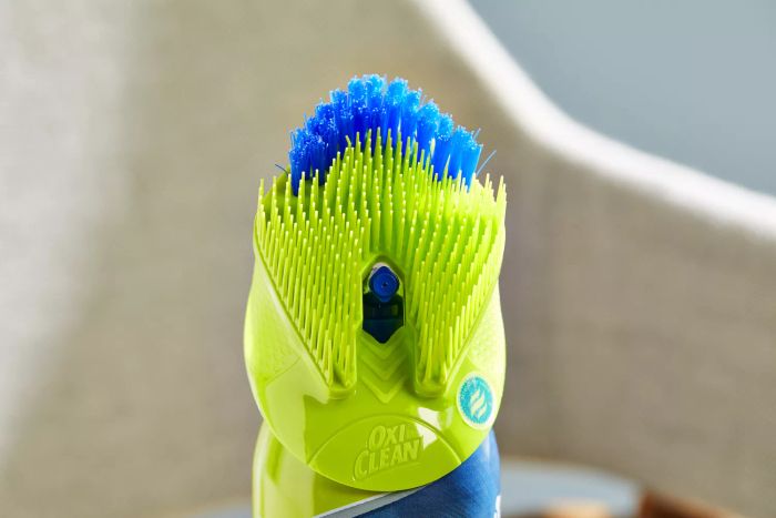 A close-up view of the brush attached to the OxiClean Total Interior Carpet & Upholstery Cleaner bottle