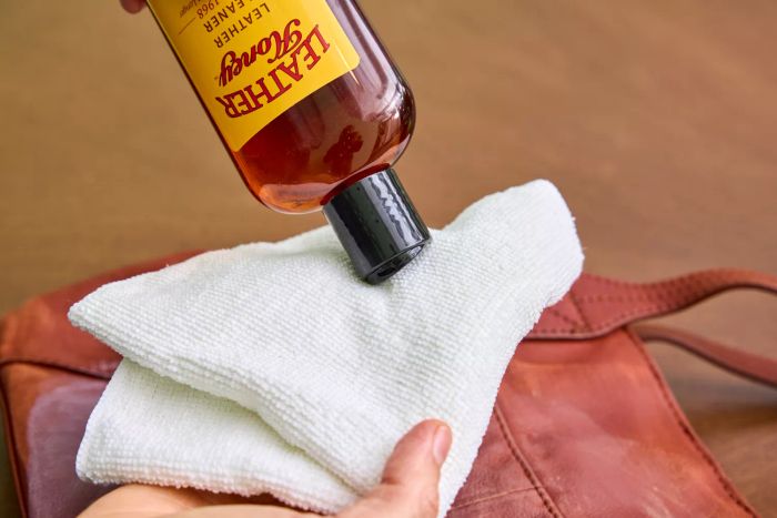 An individual applies Leather Honey Leather Cleaner to a cloth