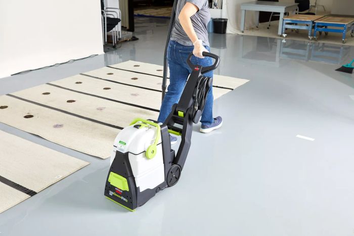 A person moving the Bissell Big Green Pet Pro Carpet Cleaner across a floor.