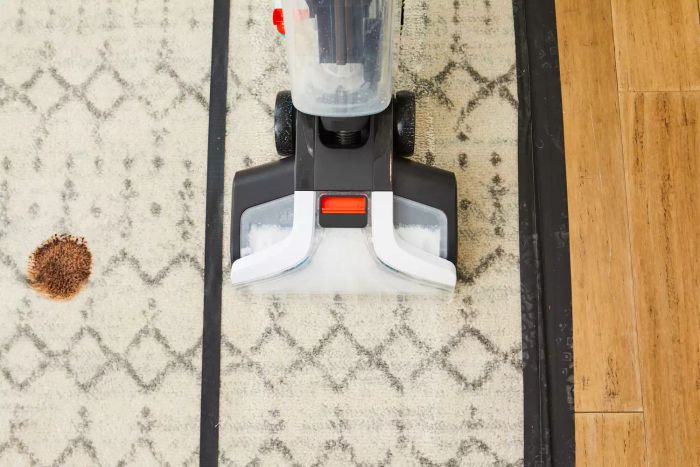 A close-up shot of the Shark CarpetXpert with Stainstrike Upright Deep Carpet Cleaner being used on a rug