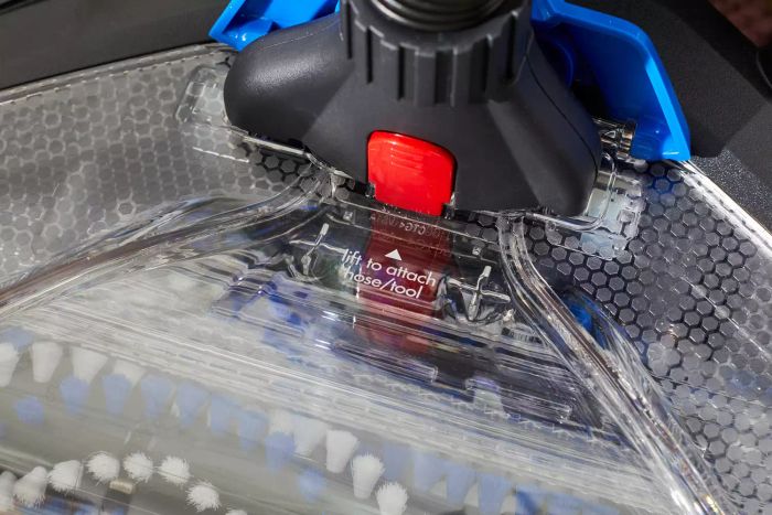 A close-up view of the button used to attach the hose or tool to a Bissell ProHeat 2X Revolution Pet Carpet Cleaner 35799