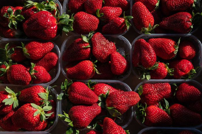 image of market stalls filled with containers of fresh strawberries