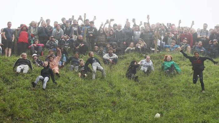 Participants chasing the cheese down Cooper’s Hill during the 2022 Cheese-Rolling competition.