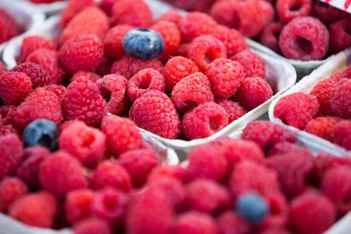 image of blueberries and raspberries on display at a market