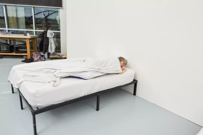 Individual sleeping on a bed dressed with The Citizenry Organic Resort Cotton Sheet Set