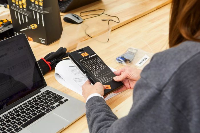 A person reading the instructions for the Oria 60-in-1 Precision Screwdriver Set