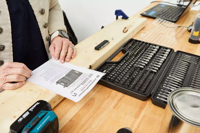 A person reading the instructions for the Jackson Palmer 218-Piece Ultimate Screwdriver Bit Set