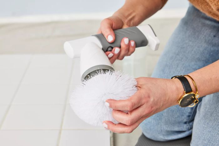 A close-up of hands holding an IEZFIX Electric Spin Scrubber
