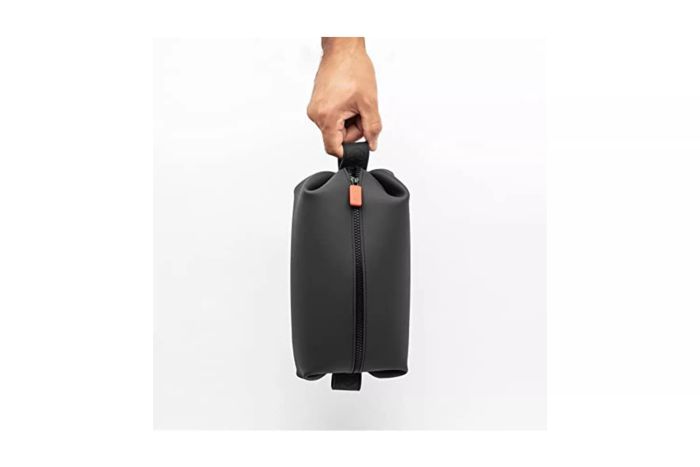 An individual holding a bag from the Tooletries Koby Dopp Kit