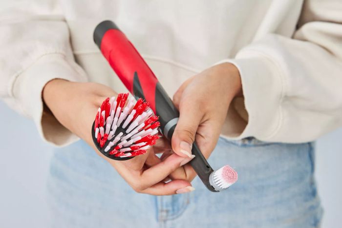 A person holds the Rubbermaid Reveal Power Scrubber along with one of its attachments