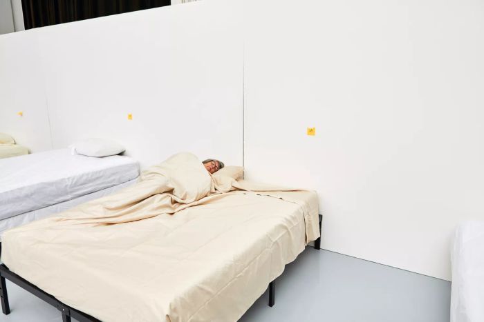 Individual lying on a bed dressed with the Lands' End 400 Thread Count Premium Supima Cotton No Iron Sateen Bed Sheet Set