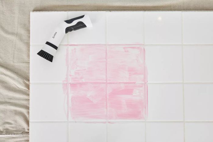 A Klever Electric Spin Scrubber with 8 Brushes rests on white tile stained with red marker