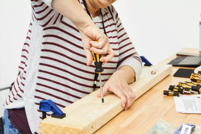 A person securing a screw using the Amartisan 10-Piece Magnetic Screwdrivers on a wooden piece