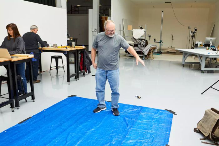 A person dropping the DeWalt Screwdriver Bit Set With Tough Case onto a blue tarp during testing