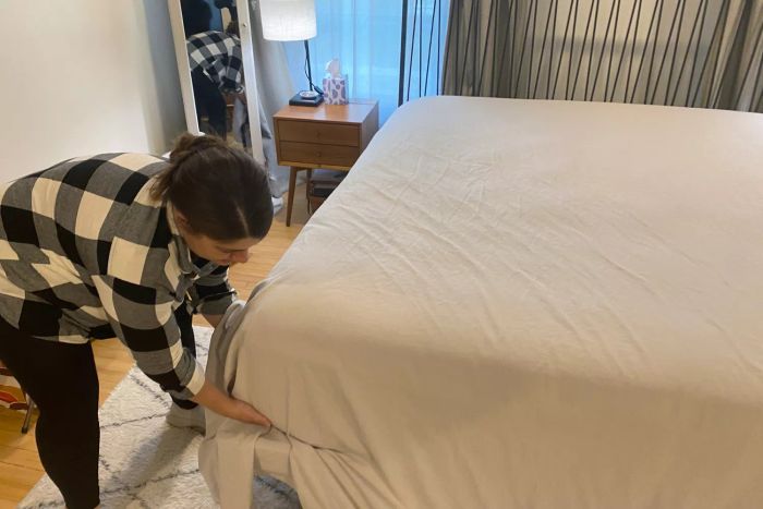 Individual making a bed with the Lands’ End Comfy Super Soft Cotton Flannel Sheet Set