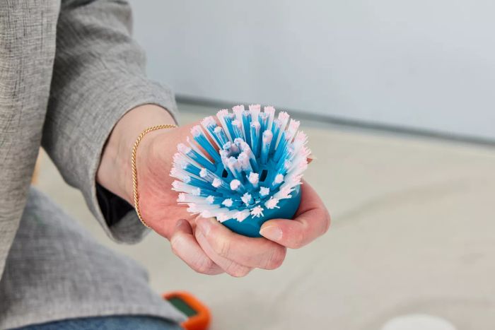 A person holds the bristle brush attachment for a Black+Decker Grimebuster Pro Power Scrubber Brush