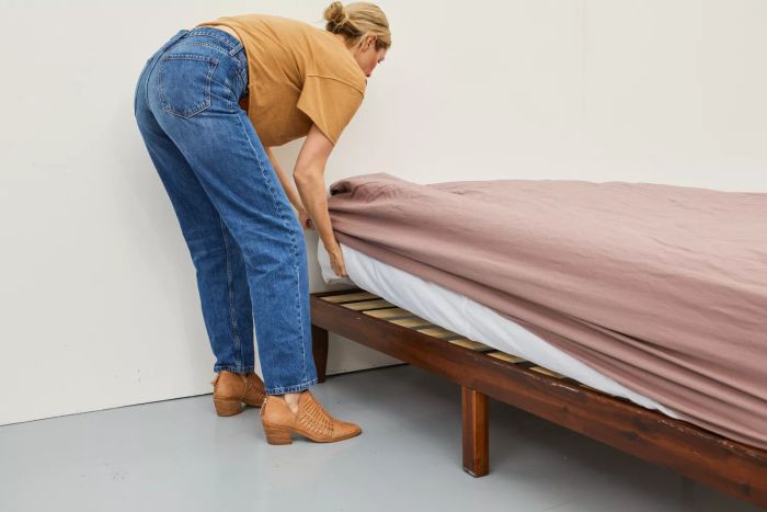 Person securing the Parachute Brushed Cotton Sheet Set onto the mattress