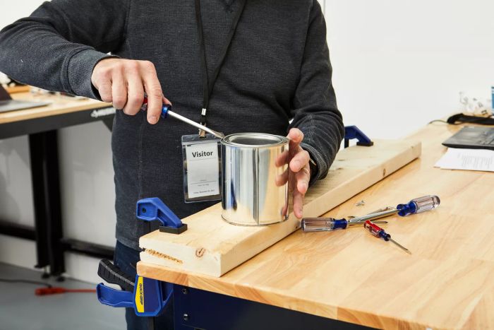 A person using the Craftsman 5-Piece Screwdriver to open a tin lid