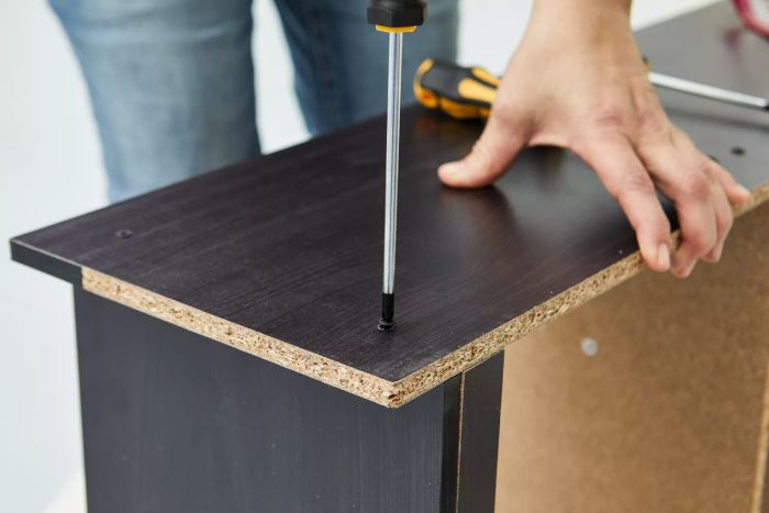 A person tightening a screw using the Amartisan 10-Piece Magnetic Screwdrivers on a wooden piece