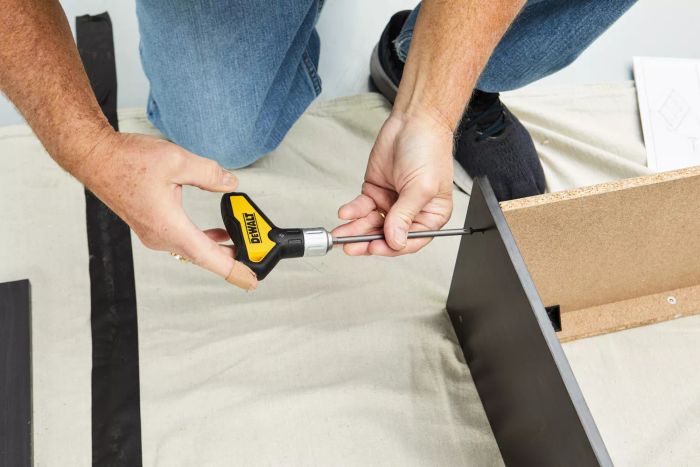 A person utilizing the DeWalt Screwdriver Bit Set With Tough Case to secure a screw on a wooden shelf