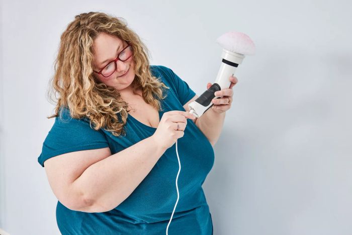 A person holds a Klever Electric Spin Scrubber with 8 Brushes