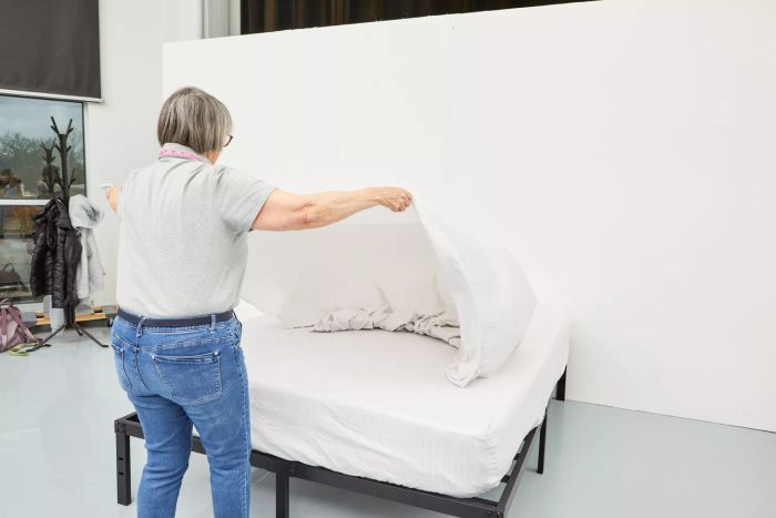 Individual spreading The Citizenry Organic Resort Cotton Sheet Set onto a bed