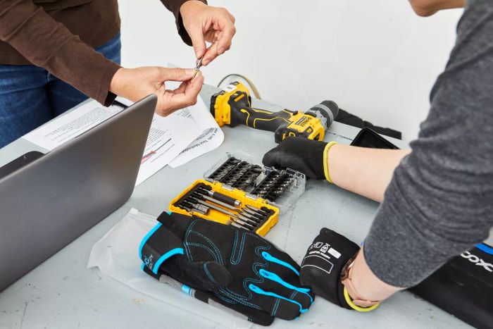 Two individuals standing near a DeWalt Screwdriver Bit Set With Tough Case placed on a table
