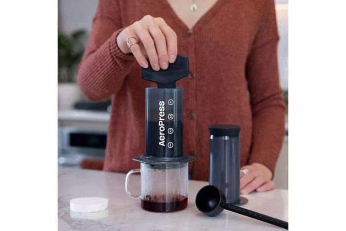 A person uses the AeroPress Original Coffee Maker