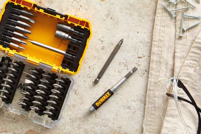 DeWalt Screwdriver Bit Set With Tough Case placed on a beige surface alongside a towel and screws