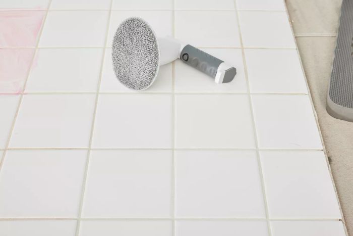 An IEZFIX Electric Spin Scrubber lies on white tile
