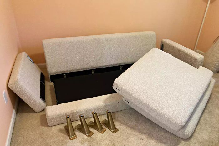 Pieces of the Albany Park Lido sofa placed on the floor of a carpeted room