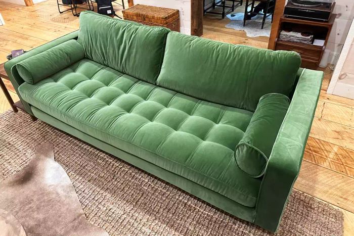A green Article Sven Sofa elegantly placed in a modern living room