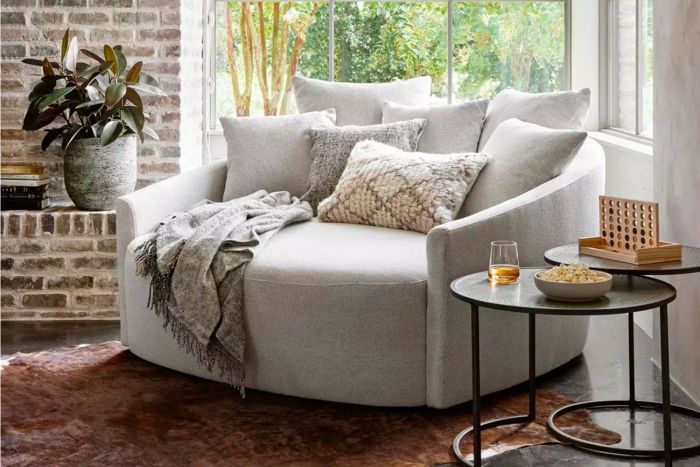Kaila Media Lounger placed in a room corner beside a plant and side tables