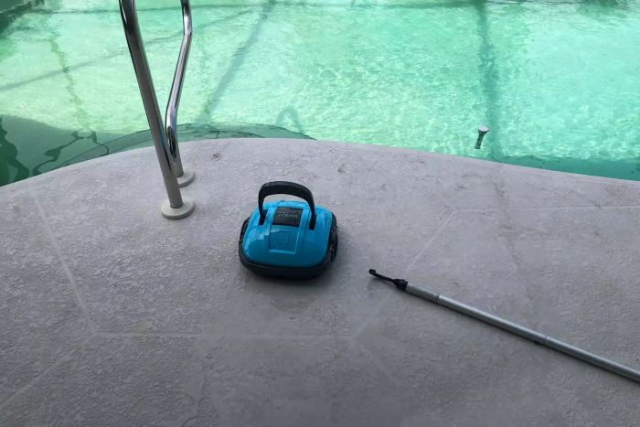 The WYBOT Cordless Robotic Pool Cleaner placed near the edge of a pool