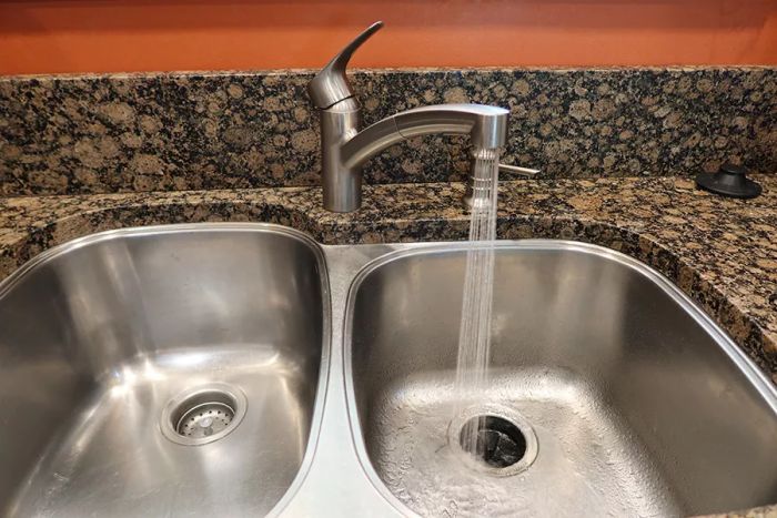 Water flowing from the Grohe 30306DC1 Eurosmart Dual Spray Pull-Out Kitchen Faucet with Sprayer into a sink