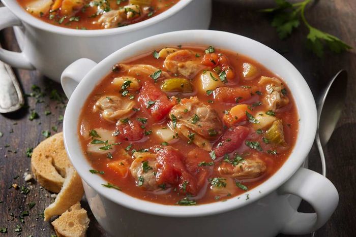 A mug of tomato-based clam chowder.