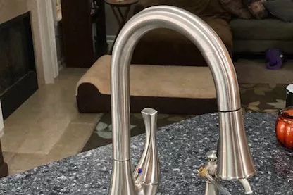 The BioBidet Flow Pull-Down Sprayer Faucet With Motion Sensor mounted on a kitchen sink.