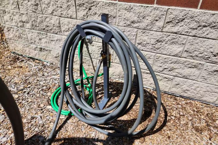 A hose coiled around the AQUA JOE 125 ft. Capacity Garden Hose Stand with Brass Faucet