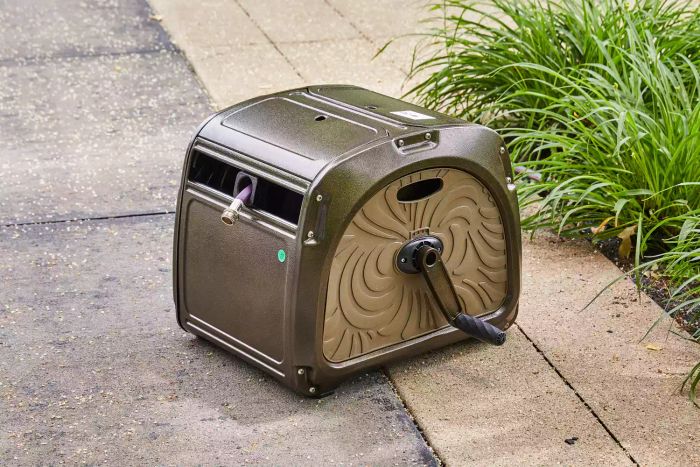 Giraffe Metal Hose Reel Box placed on a terrace floor surrounded by plants