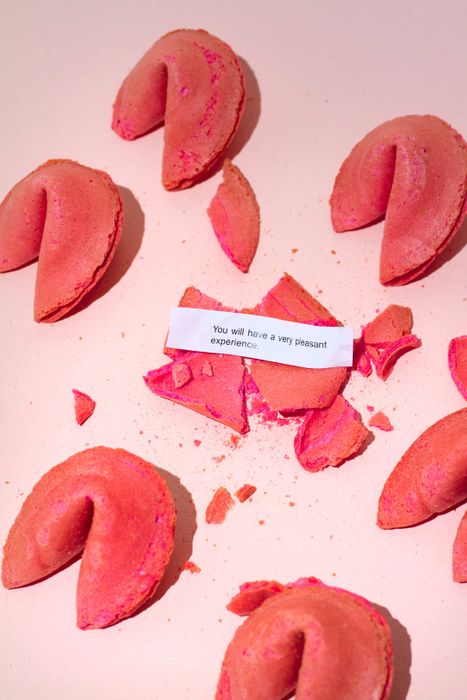 Red fortune cookies displayed against a pink backdrop.