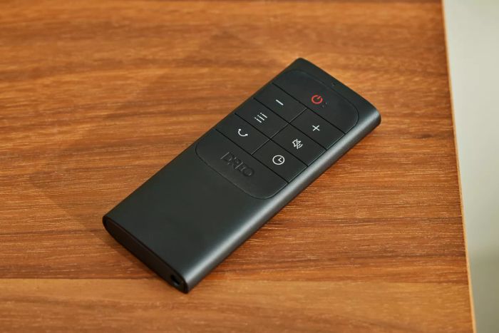 A close-up view of the remote control for the Dreo Nomad One Tower Fan for Home placed on a wooden table